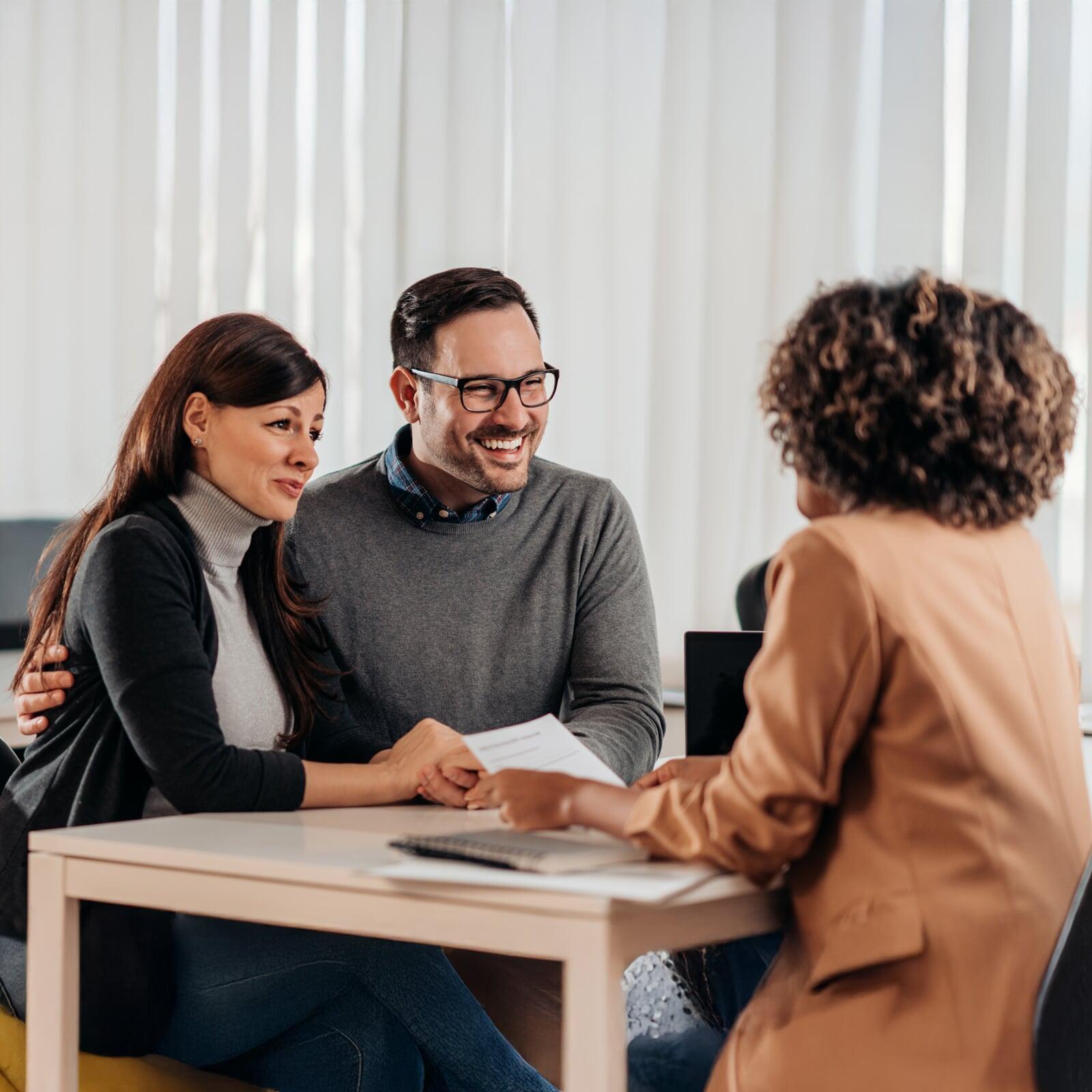 Couple sitting down with financial advisor looking at investment options