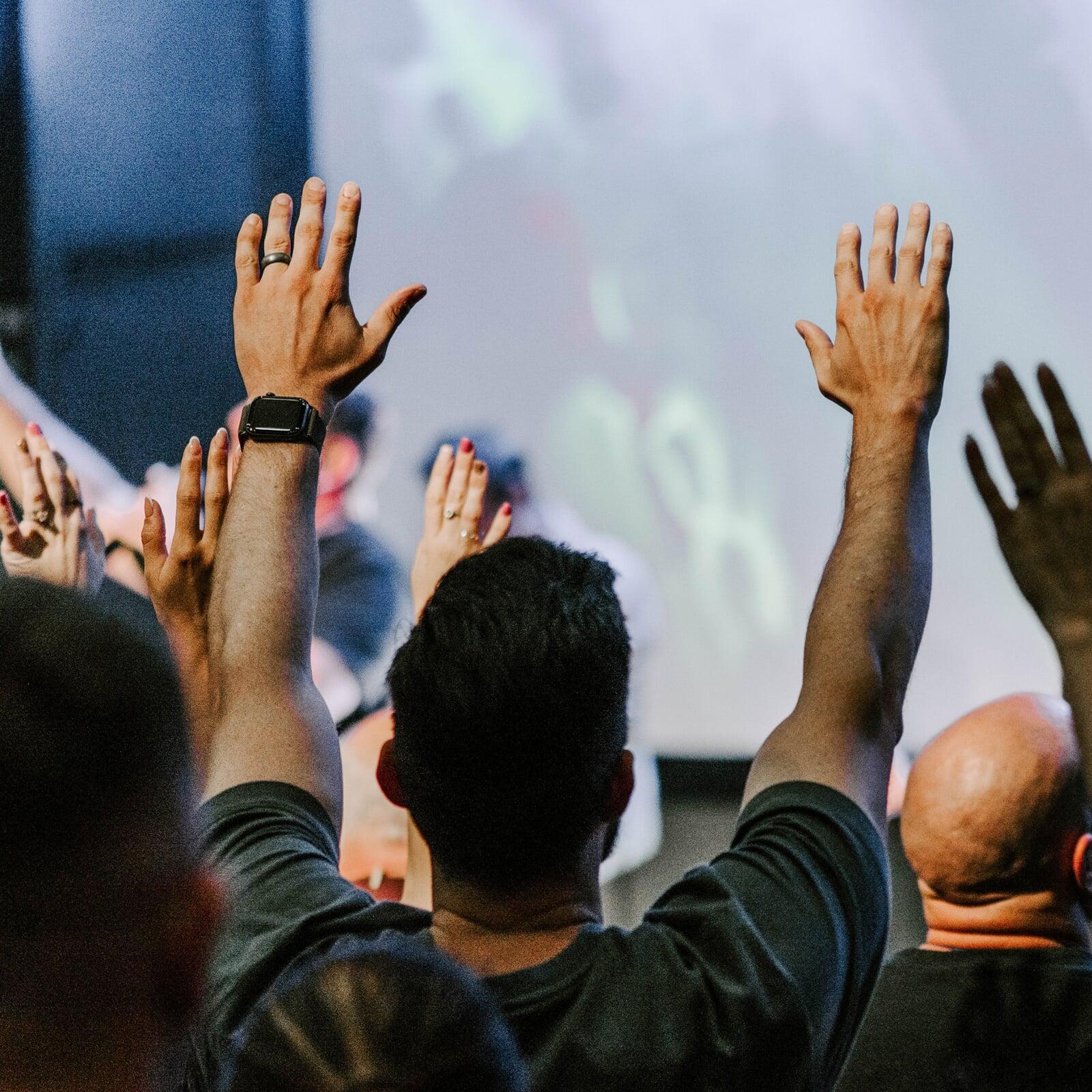 People raising hands in worship at church