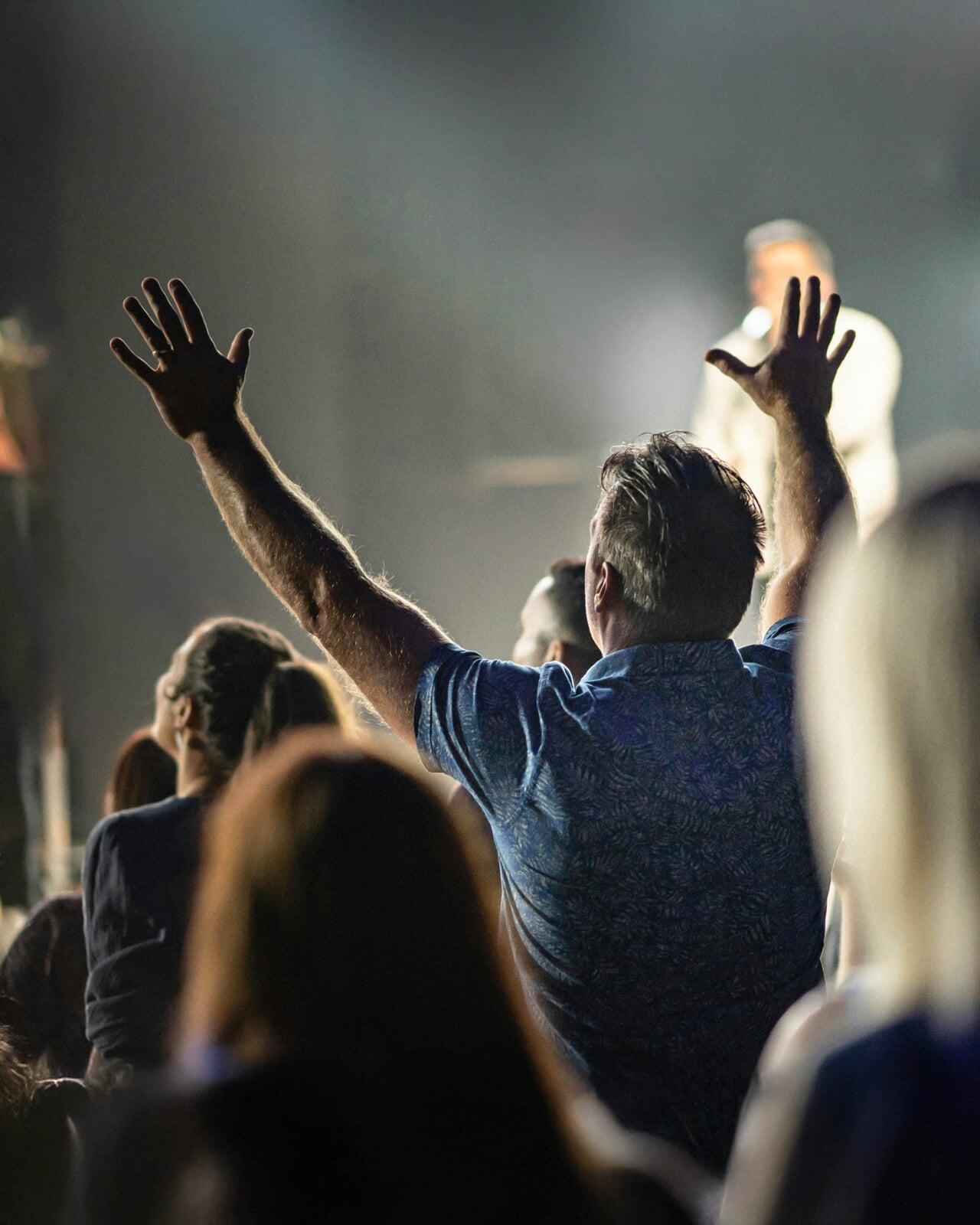 Man raising this hands in worship at church.